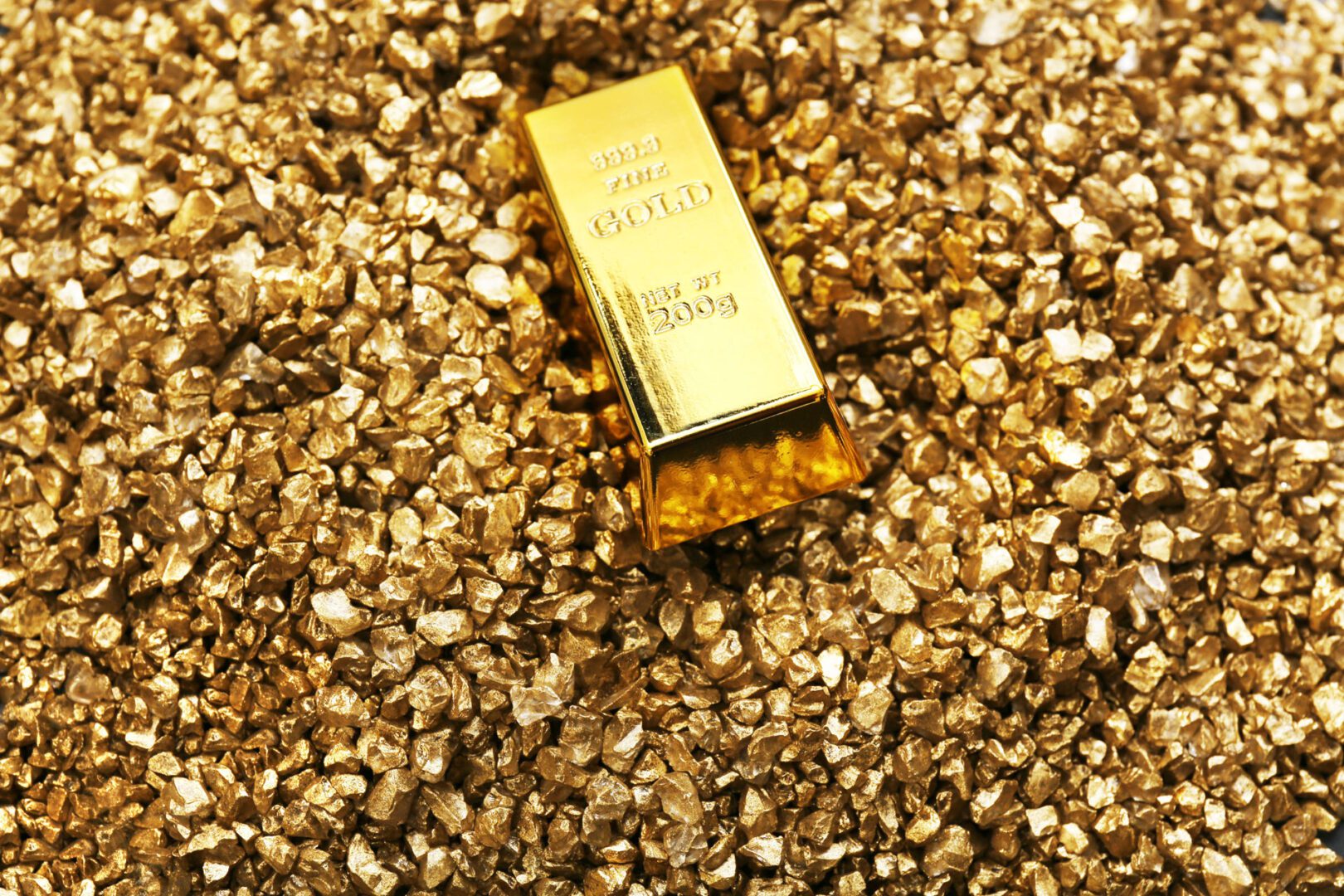 Gold bars on nugget grains background, close-up